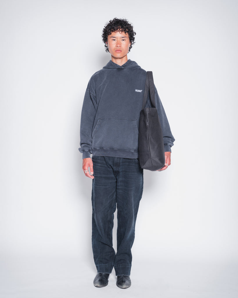 Model wearing recycled oversize black tote bag and Ikono oversize vintage black hoodie. 